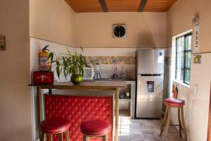 uma cozinha com uma cadeira vermelha e um balcão com um frigorífico em Bio-Hotel entre café, bosque y montañas em Cachipay
