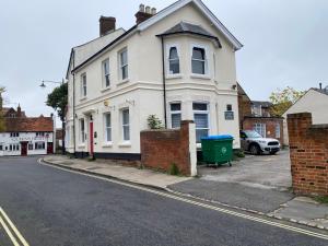 a white house on the side of a street at Buckinghamshire Elegant Studio in Buckinghamshire