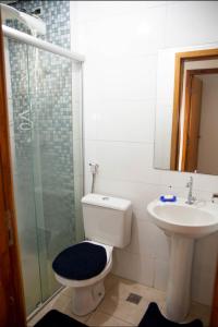 a bathroom with a toilet and a sink and a shower at Geovane Acomodação in Boituva