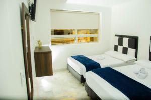 a hotel room with two beds and a window at CASA HOTEL LOS ARBOLES in Bello