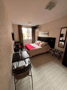 1 dormitorio con 1 cama, mesa y sillas en Monoambiente Frente Al Hospital Italiano en Buenos Aires