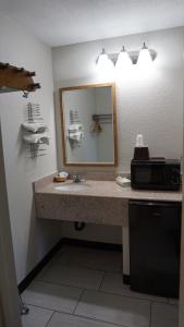 y baño con lavabo y espejo. en Travel Inn Tucson, en Tucson