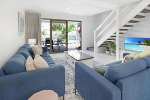 een woonkamer met blauwe banken en een tv bij Noosa Place Resort in Noosaville