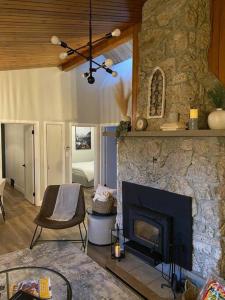 a living room with a stone fireplace with a chair at Charming Nordic Style - 2BR + 1 Bath Entire House in Sudbury