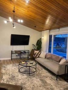 ein Wohnzimmer mit einem Sofa und einem Flachbild-TV in der Unterkunft Charming Nordic Style - 2BR + 1 Bath Entire House in Sudbury