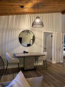 einen Tisch mit Stühlen und einen Spiegel im Zimmer in der Unterkunft Charming Nordic Style - 2BR + 1 Bath Entire House in Sudbury