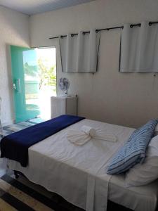 a bedroom with a large bed with blue and white sheets at Pousada Recanto da Preguiça in Jarinu