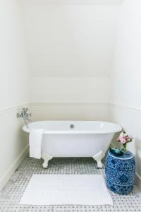 a white bath tub in a bathroom with white walls at Gardiner House in Newport