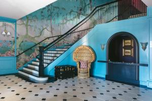 Una escalera con paredes azules y un mural de árboles. en Gardiner House, en Newport