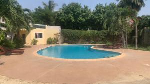 a small swimming pool in a yard with two benches at Ker mame fatou in Sali Nianiaral