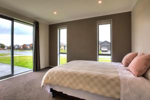 a bedroom with a large bed and large windows at Cambridge Sunshine 5 Bedrooms House in Cambridge