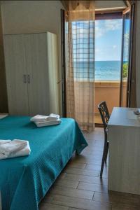 een slaapkamer met een bed en uitzicht op de oceaan bij B&B Benvenuti al Sud in Crotone