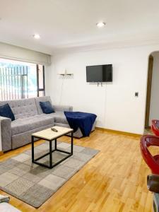 a living room with a couch and a table at HERMOSO APTO CHICO in Bogotá