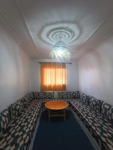 - un salon avec un canapé et une table dans l'établissement Appartement Sariq Ouarzazate, à Ouarzazate