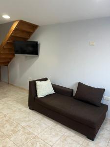Sofá marrón en una habitación con TV en la pared en Mara Patagónica - Apartments en Río Gallegos