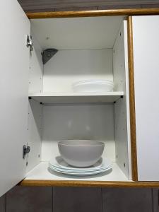 a cabinet with a bowl and plates in it at Mara Patagónica - Apartments in Río Gallegos