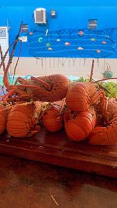 a pile of lobsters sitting on a wooden table at Condomínio Lene Andrade in Guaibim