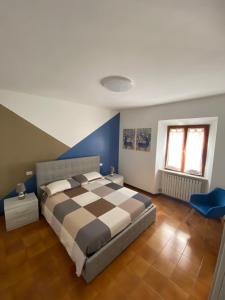 una camera con un letto dotato di copriletto a scacchi di Una notte sul colle a Recanati