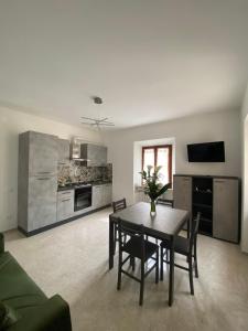 un soggiorno con un tavolo e una cucina di Una notte sul colle a Recanati