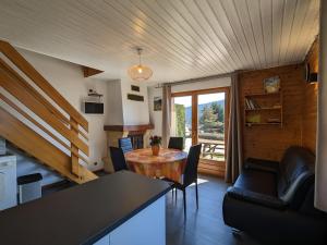 eine Küche und ein Wohnzimmer mit Tisch und Stühlen in der Unterkunft Chalet familial avec cheminée à Gérardmer - FR-1-589-37 in Gérardmer