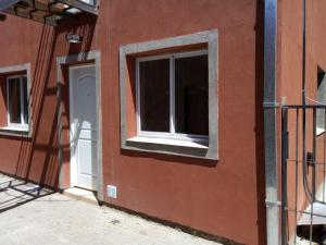 - un bâtiment rouge avec une fenêtre et une porte blanche dans l'établissement Departamento Estrada, à Santa Rosa