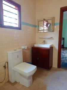 een badkamer met een wit toilet en een wastafel bij Villa privée avec garden à bord de plage in Cotonou