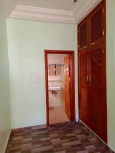 een kamer met een badkamer met een deur en een wastafel bij Villa privée avec garden à bord de plage in Cotonou