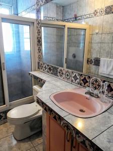 La salle de bains est pourvue d'un lavabo rose et de toilettes. dans l'établissement The Temple, Quito, à Quito