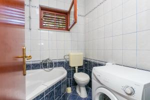 a bathroom with a toilet and a sink and a window at Apartment Seget Vranjica 1038b in Seget Vranjica
