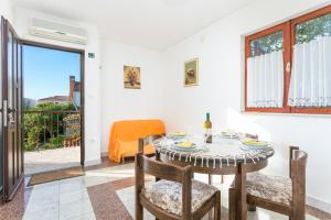 a dining room with a table and chairs and a window at Apartment Seget Vranjica 1038b in Seget Vranjica