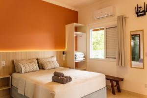 Un dormitorio con una cama grande y una ventana en Solarium Flats Itagua - Ubatuba SP en Ubatuba