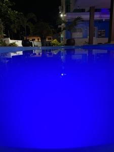 a swimming pool at night with blue illumination at Condomínio Lene Andrade in Guaibim