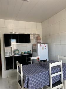 a small kitchen with a table and a refrigerator at Aconchego MCC in João Pessoa