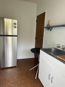 a kitchen with a stainless steel refrigerator and a sink at Totara Vale, Free Coffee, parking and wifi, near Glenfield Mall and highway 18,1 in Auckland
