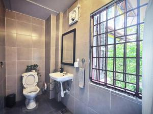 a bathroom with a toilet and a sink and a window at LEJU 21 樂居 Explore Malacca from a riverside house in Melaka +32 photos