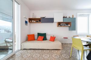 Habitación con cama con almohadas de color naranja y verde. en Comfort a 150 mt dal mare, en Torre dell'Orso