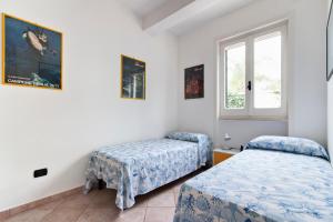 1 dormitorio con 2 camas y ventana en Comfort a 150 mt dal mare, en Torre dell'Orso