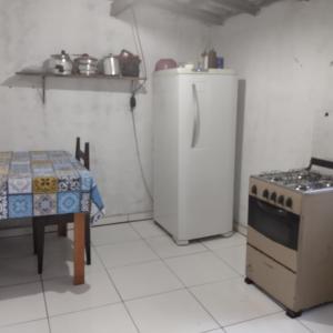 a kitchen with a stove and a table in it at João de Barro Hospedagem in Caeté-Açu