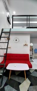 a loft bed with a red couch in a room at SKY HOMESTAY in Buon Ma Thuot