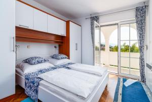 a bedroom with a bed and a large window at Apartments with a parking space Banjol, Rab - 5022 in Rab