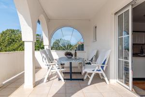 a dining room with a table and chairs on a balcony at Apartments with parking space Banjol, Rab - 5022 in Rab