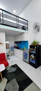 SKY HOMESTAY في بون ما توت: غرفة معيشة مع أريكة حمراء ومطبخ