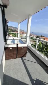 un balcon avec vue sur une piscine dans l'établissement Madeira Panoramic Villa- Promoção 2 ou 3 semana, à Funchal
