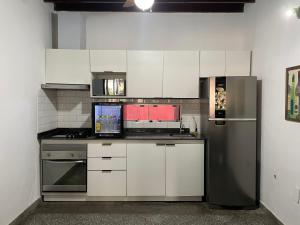 a kitchen with white cabinets and a refrigerator at Dormitorio privado con desayuno incluido in Asuncion
