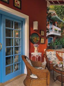 un patio con sillas, una mesa y una puerta en La Belle Provence, en Itaipava