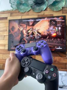 a person holding two video game controllers in front of a tv at Stunning Taal View Staycation in Tagaytay in Tagaytay