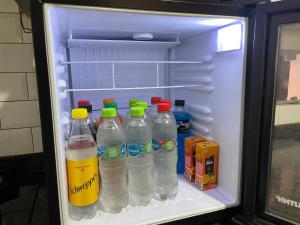 an open refrigerator filled with bottles of water and milk at Dormitorio privado con desayuno incluido in Asuncion