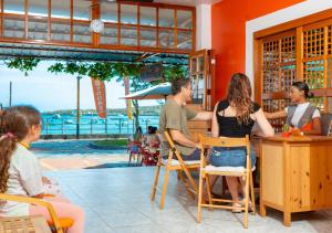 un groupe de personnes assises dans un bar dans l'établissement La Zayapa Hotel, à Puerto Baquerizo Moreno