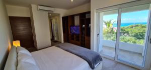 una camera da letto con un letto e una porta scorrevole in vetro di CASA REYES Stunning Rooftop Oceanview a Isla Mujeres Altre 43 foto