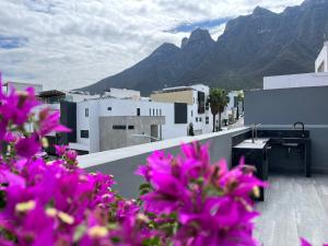 un ramo de flores rosas en un balcón con montañas en Amplia casa de 5 habitaciones, estilo, confort y diseño único garantizados, en Monterrey